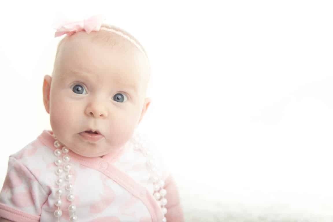 bébé avec un gros collier de perle