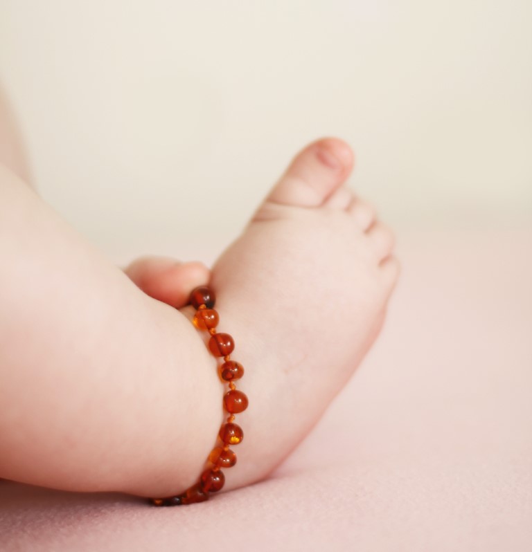 Un collier d'ambre bébé porté en bracelet