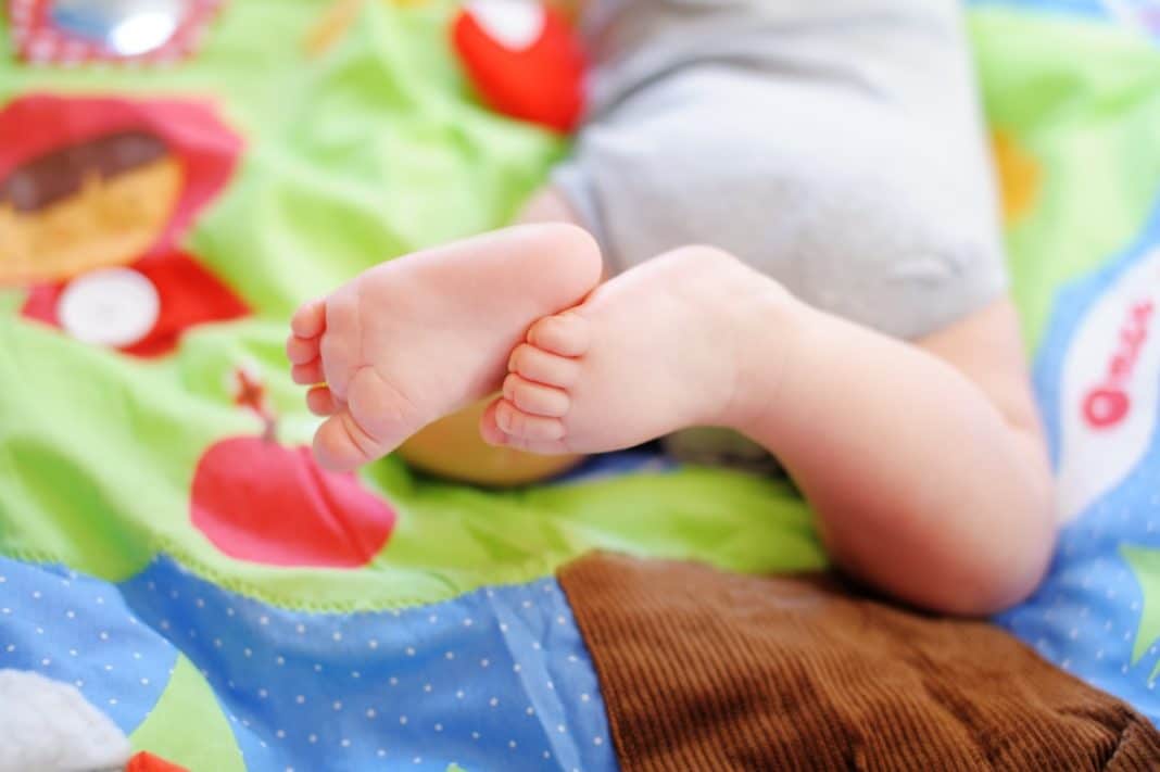 Bébé jouant sur tapis d'éveil Montessori