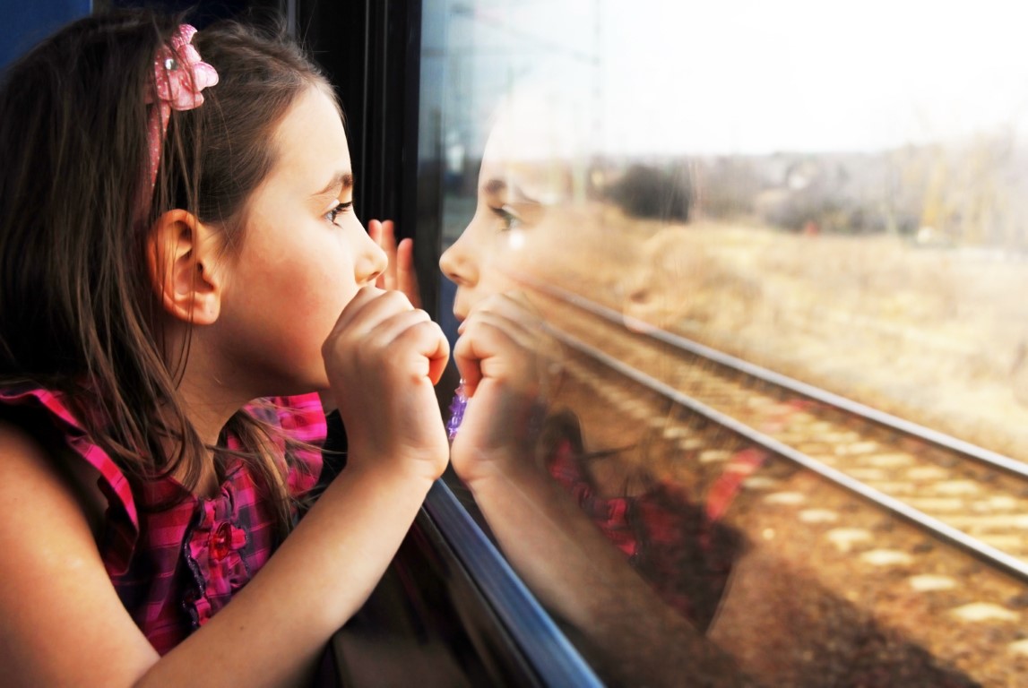 fillette qui regarde par la vitre d'un train