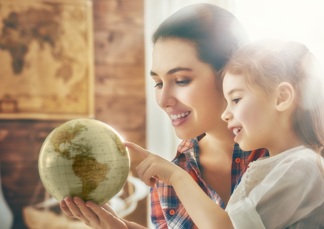 petite fille et sa mère qui regarde un globe terrestre