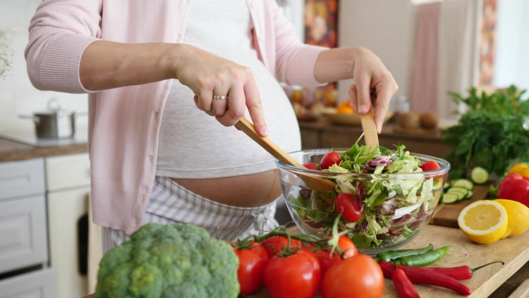 Femme enceinte se préparant un repas