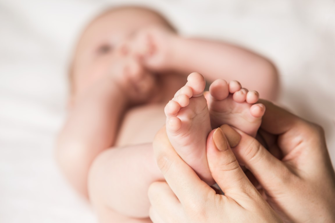 Masser les pieds de bébé avec des mouvements circulaires